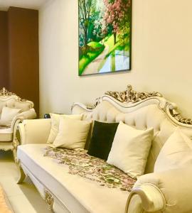 伊斯兰堡Atrium high Suite 2bed family apartment near Giga Mall的卧室配有白色的床和绘画作品