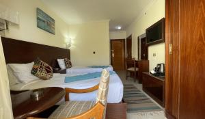马特鲁港Delmar Hotel Matrouh的酒店客房配有两张床和一张书桌