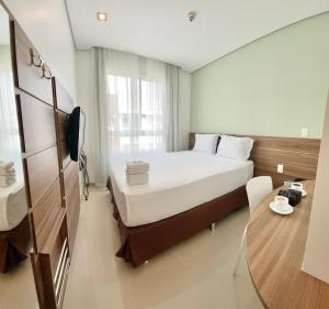 马瑙斯维尔弗斯机场快线酒店的酒店客房设有一张大床和一张桌子。