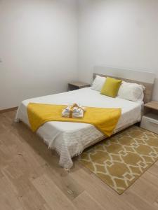 布拉干萨IPB Studios的一间卧室配有一张黄色毯子床
