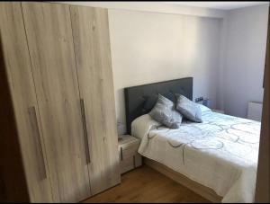 索特Precioso apartamento con piscina, ideal familias!的一间卧室配有一张床和一个大型木制衣柜