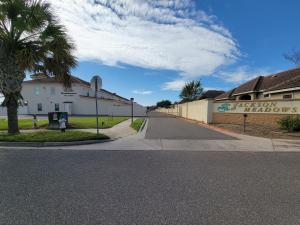 麦卡伦Modern, Private, Smart 4 BR Condo in Desirable Location in McAllen with Pool!的一条空的街道,有建筑和棕榈树