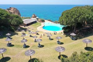 阿尔沃尔Casa da Prainha - private pool, next to the beach的一组桌子和遮阳伞,位于游泳池旁
