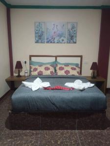 邦劳Peace Lily Studio Apartments Panglao的一间卧室配有一张床,上面有两条毛巾