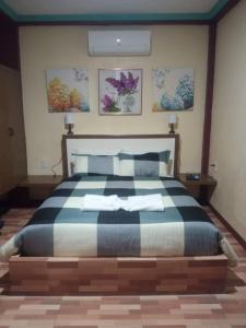 邦劳Peace Lily Studio Apartments Panglao的一间卧室配有一张大床和两条毛巾