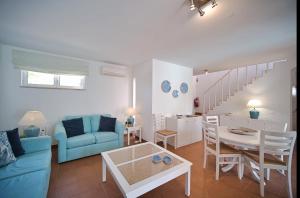 阿尔沃尔Casa da Prainha - private pool, next to the beach的客厅配有蓝色的沙发和桌子