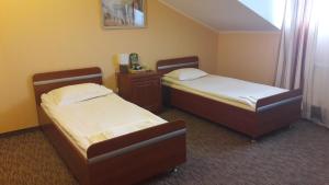 乌日霍罗德宜兹木尔德酒店的配有衬衫的酒店客房内的两张床