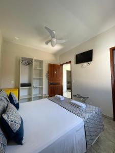 乌巴图巴Pousada Serrate的卧室配有一张白色大床和一台平面电视。