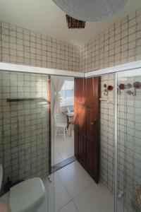 纳塔尔Pousada Recanto da Família的带淋浴的浴室和玻璃门