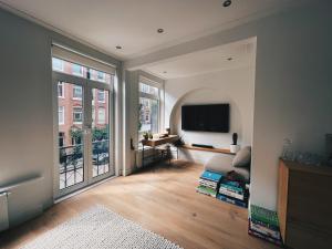 阿姆斯特丹Spacious Designer Duplex next to Central Park的客厅设有大窗户和电视。