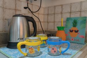 纳塔尔Pousada Recanto da Família的厨房柜台配有茶壶和3杯