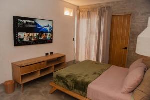 拉巴斯MANGLITO MANILA的卧室配有一张床,墙上配有电视。