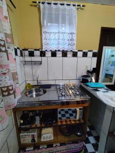 蜜岛Morada das Flores Chalé/Kitnet的小厨房配有炉灶和水槽