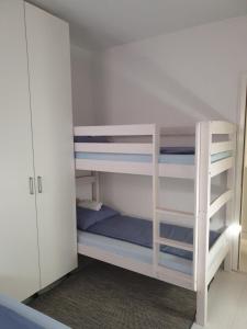 弗拉西克Apartmani Šišava apt "HARMONY" Vlašić的白色双层床间 - 带蓝色和白色的双层床