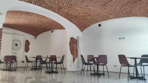 诺瓦拉Novara的一间设有桌椅和砖砌天花板的房间