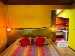 蒙泰韦尔德哥斯达黎加El Sol Monteverde的一间卧室配有一张带两个红色枕头的床