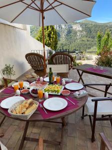 Margaridaal-qandil的一张带食物和饮料的野餐桌和一把雨伞