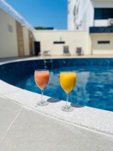 马瑙斯圣保罗公寓的两杯酒杯坐在游泳池旁