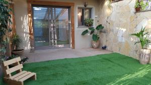 Kefar WeradimRosewood的房屋前方的庭院,铺着绿色地毯