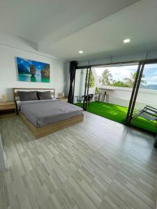 芭东海滩Garden Beach Sea View Patong的一间卧室设有一张床和一个大窗户