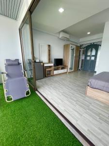 芭东海滩Garden Beach Sea View Patong的一间铺有绿色地毯的卧室、一张床和一张书桌