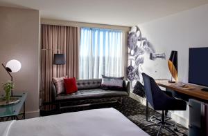 洛杉矶帕洛玛金普顿酒店，洛杉矶比佛利山庄的酒店客房配有一张床、一张书桌和一张沙发。