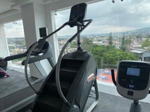 瓜达拉哈拉Hotel ANB Aeropuerto Guadalajara的享有城市美景的健身房内的跑步机