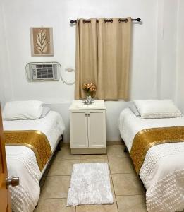 Sabana GrandeGreat Savannah Guesthouse的客房设有两张床和一个带加热器的窗户。