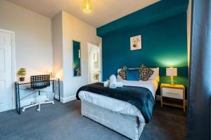 BrightsideSheffield Contractors Stays- Sleeps 6, 3 bed 3 bath house. Managed by Chique Properties Ltd的一间卧室设有一张床和蓝色的墙壁