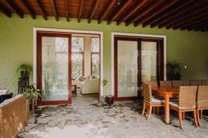 利马Casa de Campo en Cieneguilla的配有桌椅和绿色墙壁的客房