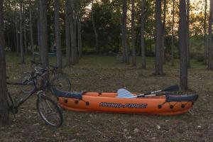 洛兹尼察Drina River Glamping的一辆橙色皮艇停在自行车旁边