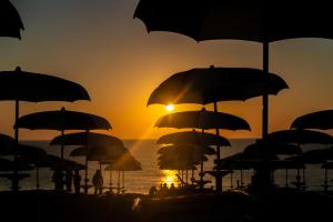 马瑟利Crystal Camere的日落时分在海滩上放一把遮阳伞