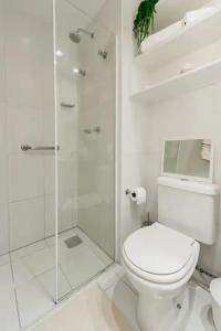 里约热内卢Suite Verano Stay的白色的浴室设有卫生间和玻璃淋浴间。
