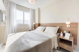 里约热内卢Suite Verano Stay的白色的卧室设有一张大床和一个窗户