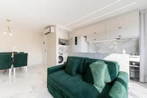 里约热内卢Suite Verano Stay的一间位于白色房间的客厅,客厅配有绿色沙发