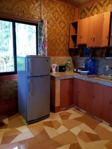 曼巴豪Paco's Garden Home Stay的厨房配有冰箱和窗户。