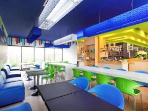 雅加达雅加达达安莫戈特宜必思快捷酒店的餐厅设有绿色和蓝色的椅子和桌子