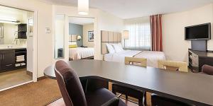 韦伯斯特Sonesta Simply Suites Houston – NASA Clear Lake的酒店客房设有书桌,房间带两张床。