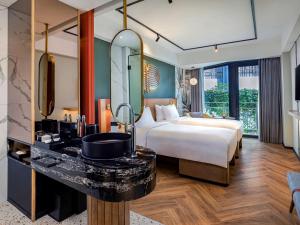 库塔Tribe Bali Kuta Beach的酒店客房,配有床和镜子