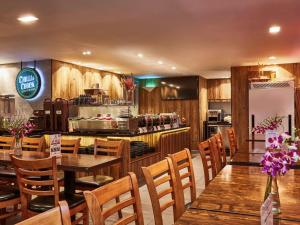 新加坡ibis budget Singapore Selegie的一间带木桌椅的餐厅和一间厨房