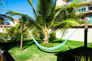 阿奎拉兹BEACH PARK PALM - COBERTURA Luxo的吊床挂在两棵棕榈树之间的院子