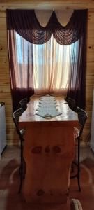 Mundo NovoCabana Campinho II的一张桌子、两把椅子和一扇窗帘窗户