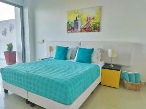 卡塔赫纳Morros Epic的一间卧室配有一张带蓝色枕头的大床
