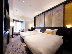 金泽金泽山乐酒店的酒店客房设有两张床和电视。