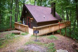 赛维尔维尔Wild Columbine - Gatlinburg Area Hottub Romantic Cabin的树林中的一个小小屋,设有一个大甲板
