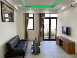 芽庄Coastal House Nha Trang的带沙发和电视的客厅