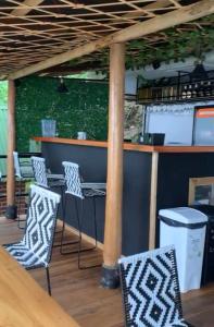 圣玛尔塔Hostal Ana的酒吧配有椅子、桌子和杆子