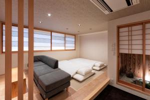 京都Rinn Gion Kenninji Villa的小房间设有床、沙发和窗户