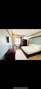 荣市Hoang Ngan 1 Hotel - TP. Vinh的一间带大床的卧室和一间客厅