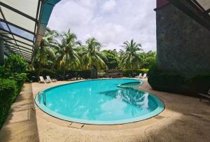 瓜埠Luï Luï Comfy Condo in Great Location的棕榈树庭院内的游泳池